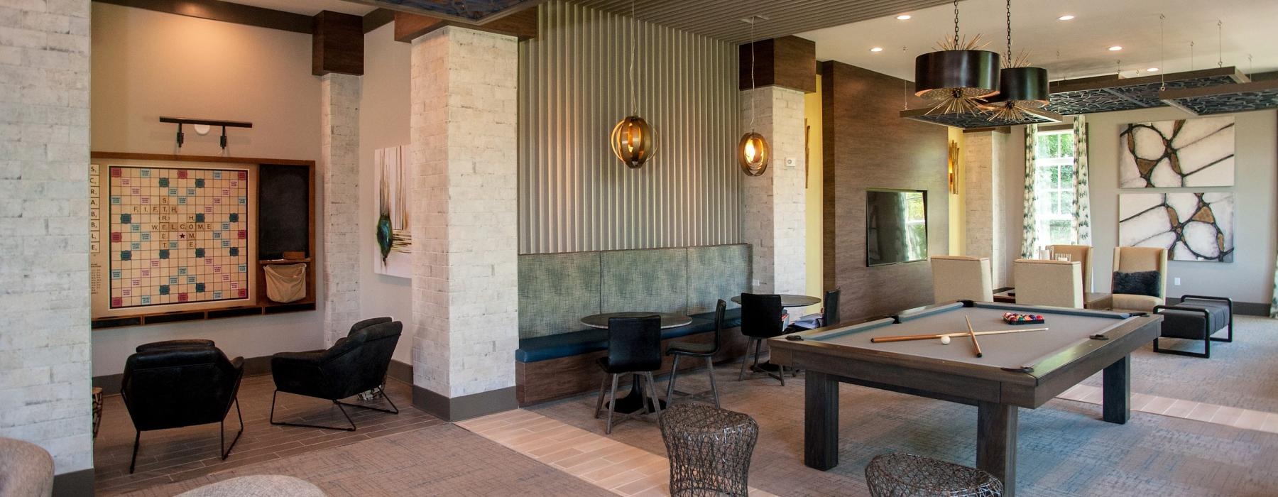 a lounge room with a pool table and chairs